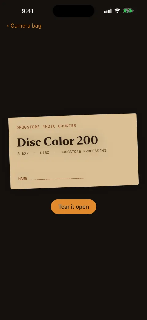 A sealed photo-finishing envelope from the drugstore photo counter, with a Tear it open button