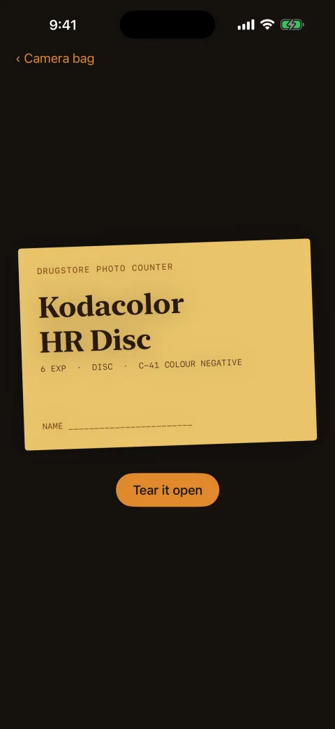 A sealed photo-finishing envelope from the drugstore photo counter, with a Tear it open button